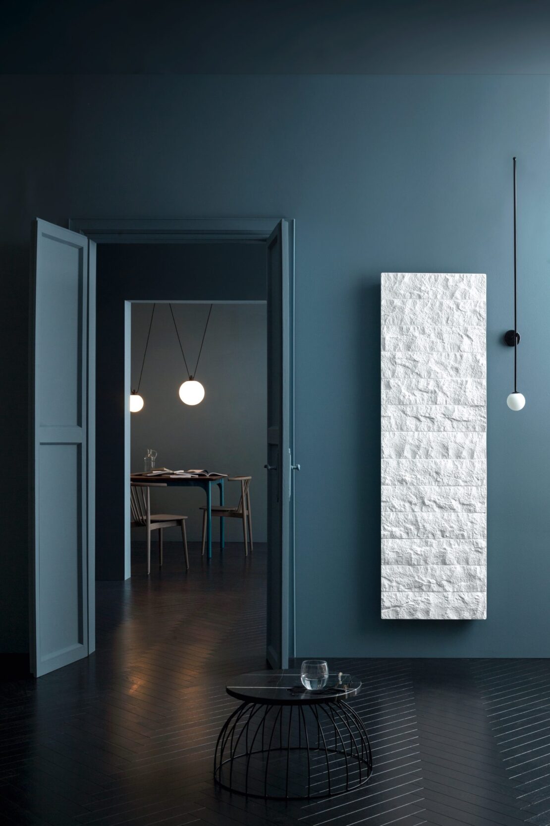Livingston Gransasso Stone Marble radiator in Bianco White in dark blue room with dark wooden floor