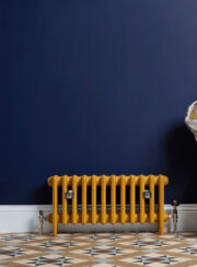 Mercury 4 Column Cast Iron radiator on tiled floor and dark blue wall in Farrow and Ball Citron