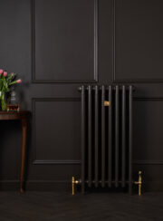 Mercury 4 Column Radiator in Chocolate on dark wood paneled wall