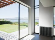 Clasico 4 Column cast iron radiator in Matt Anthracite Grey finish besides large window