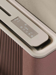 Run Cordivari Fan Coil Heating Cooling Heat Pump Radiator in Acai Red on Beige wall with easy chair