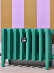 Mercury 6 column radiator painted in funky green on multicoloured wallpaper