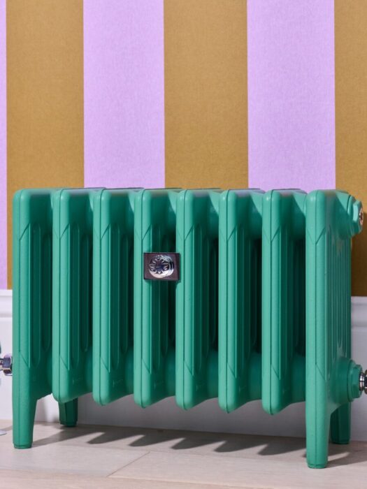 Mercury 6 column radiator painted in funky green on multicoloured wallpaper