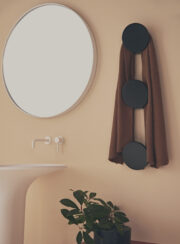 Tubes Radiatori DOTS Electric towel hanger in black by mirror and white wash basin