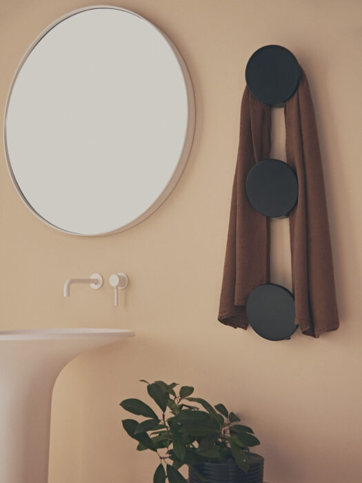 Tubes Radiatori DOTS Electric towel hanger in black by mirror and white wash basin