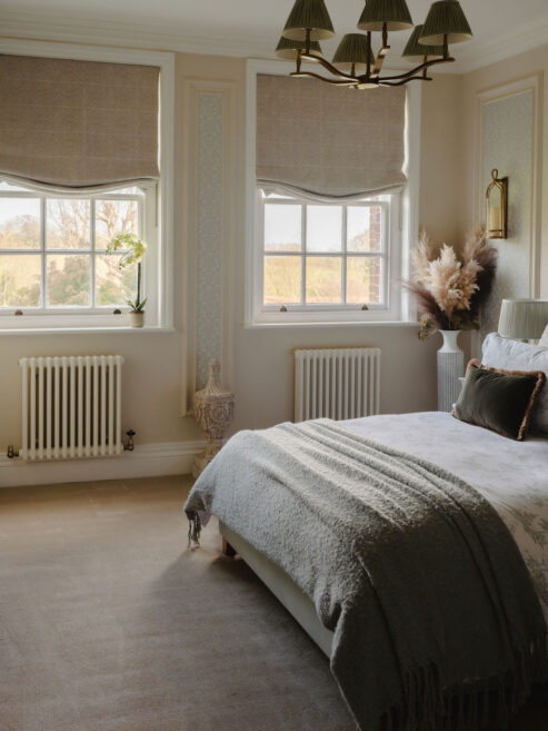 White traditional radiator shown in tranquil bedroom with period features.