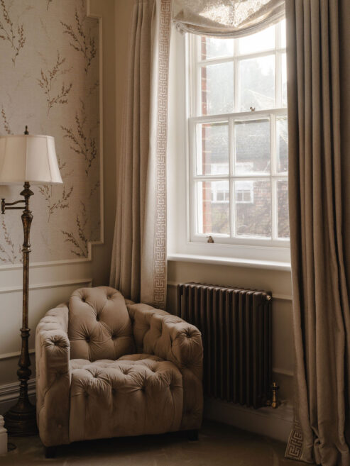 Bronze traditional radiator shown with cosy chair in period home