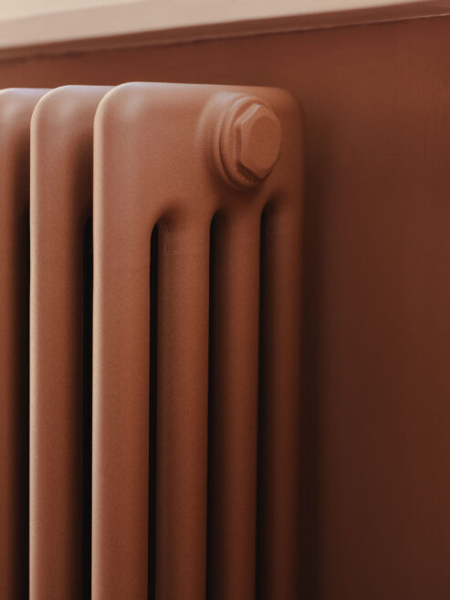 Traditional steel 4 column radiator in sandstone colour matched to bedroom wall colour