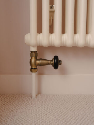Straight traditional TRV radiator valve in brass finish on column radiator