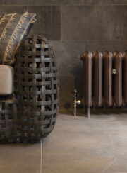 Astro II In Aged Copper Cast Iron radiator sofa and tiled floor