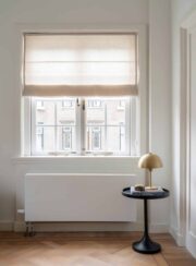 Jaga Strada Efficiency Radiator in standard white under window by gold table lamp